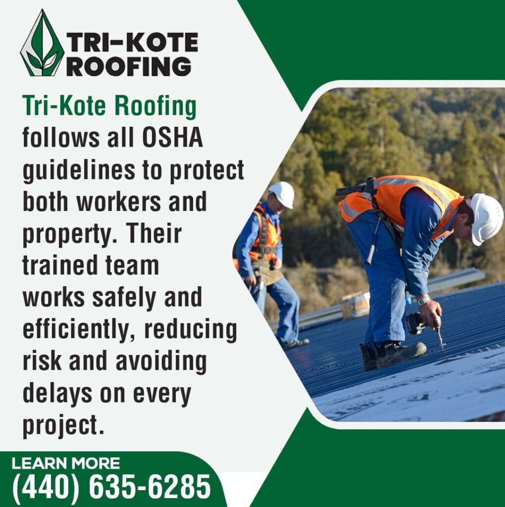 Two roofers in safety vests and hard hats are on a rooftop. One roofer is kneeling and working with a tool on a dark-colored roof membrane, while another roofer stands behind him. Trees are visible in the background.