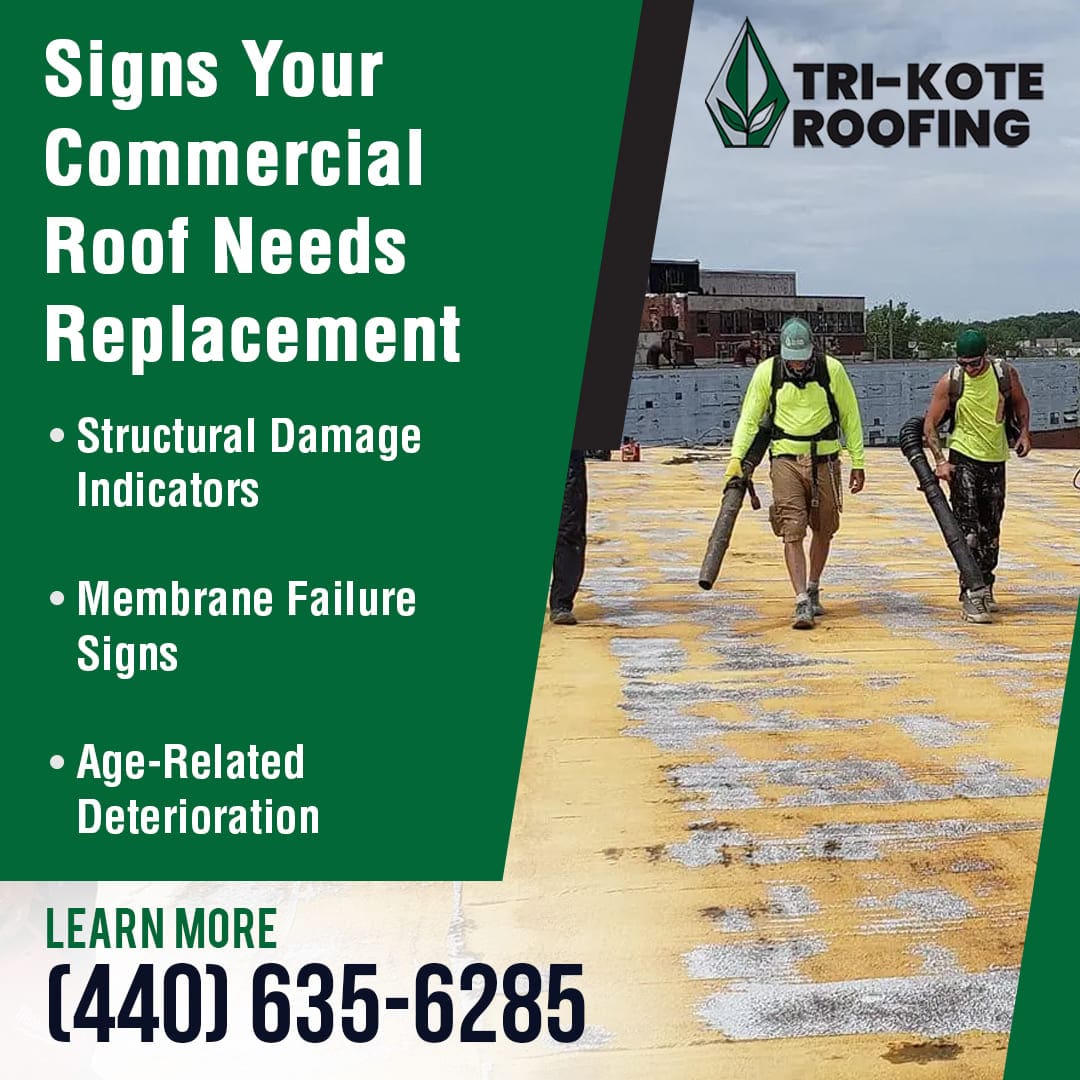 Two roofers using blowers to clean a worn and stained commercial roof.